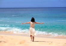 ハワイ州オアフ島のビーチで陽光を浴びる女性